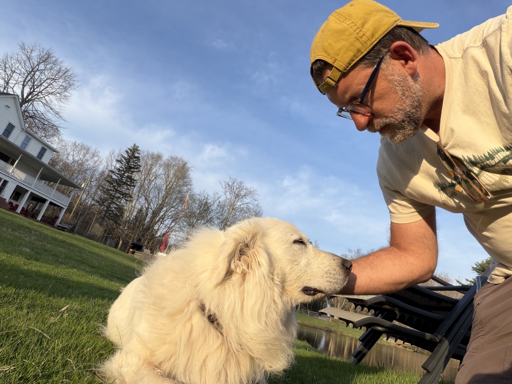 Dan Greenwald, founder of Caretaker OnCall, with a dog on a sunny property